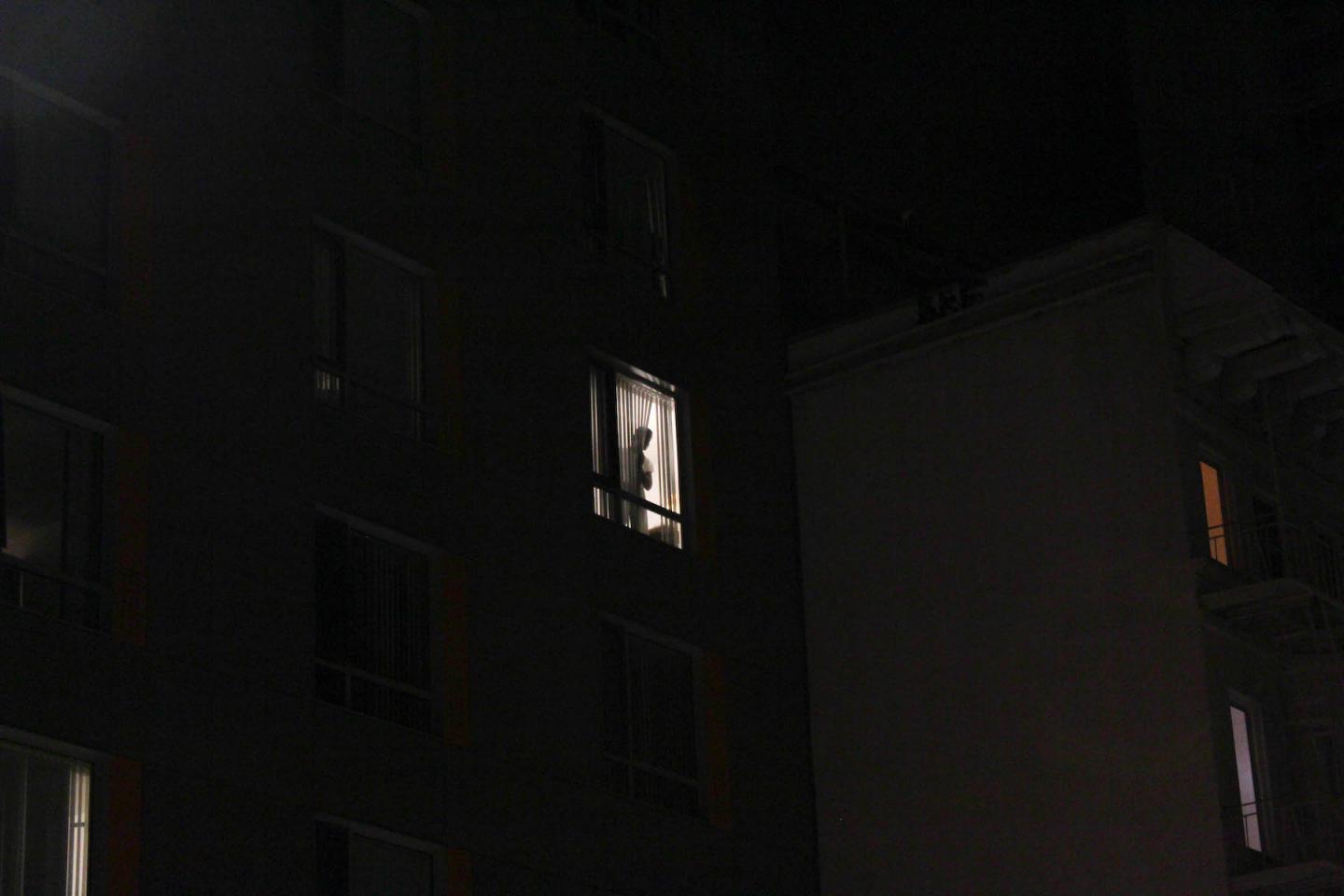 Un hombre se asoma a la ventana en el barrio del Tenderloin.