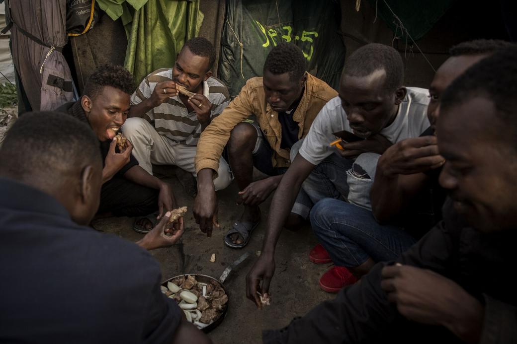 Un grupo de sudaneses comparte un plato de carne. / Olmo Calvo 