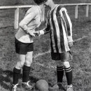 La capitana del Dick, Kerrs Ladies besa a la capitana del equipo  contrincante antes de un partido en Preston, Inglaterra en 1920. Cuando se quitaban el sombrerito, las obreras de la munición eran torreones formidables y ágiles.   