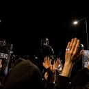 <p>Asistentes a un encuentro en defensa de la libertad de expresión en Madrid levantan las manos frente al cordón policial.</p>