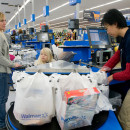 <p>Una cajera se afana por colocar en bolsas la compra de una mujer en un supermercado en EE.UU. </p>