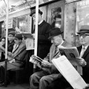 <p>Un grupo de personas lee el periódico durante el trayecto en metro. </p>