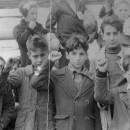 <p>Niños preparándose para la evacuación de España, durante la Guerra Civil, algunos haciendo el saludo republicano.</p>