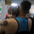 <p>Un niño gazatí abraza a su padre en un hospital de la Franja. / <strong>Mohammed Zannoun</strong></p>
