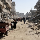 <p>Palestinos caminan entre los escombros de Shuja’iya, en el norte de Gaza. Febrero del 2024. / <strong>Mohammed Hajjar</strong></p>