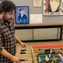 <p>Germán Labrador, comisario de la muestra, jugando con un futbolín  rojinegro, inspirado en las rivalidades entre anarquistas y comunistas. /<strong> P. C. </strong></p>