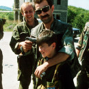 <p>Un comandante serbio pone una pistola en la cabeza de su hijo mientras él y sus amigos bromean a la esperan de un intercambio de prisioneros cerca de Sarajevo, en el verano de 1992. / <strong>Mikhail Evstafiev</strong></p>