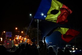 <p>Manifestantes contra la corrupción muestran banderas de Rumanía cortadas.</p>