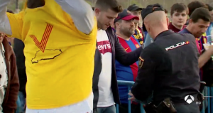 <p>Un hombre se quita una camiseta de color amarillo durante un control policial en la final de la Copa del Rey. Madrid, 21 de abril de 2018</p>