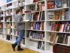 <p>Una joven en una biblioteca. </p>