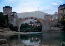 <p>El Puente Viejo de Mostar y, al fondo, la cruz levantada por las autoridades croatas en el monte desde donde sus tropas bombardeaban la ciudad.</p>