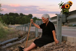 <p>María Martín, protagonista del documental ‘El silencio de los otros’, sentada en la cuneta sobre la fosa común donde está enterrada su madre.</p>