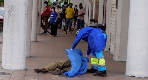 <p>Un sanitario cubre un cadáver en una calle de Guayaquil. </p>
