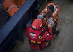 <p>Una mujer llega al barco de rescate después de ser recogida de una patera.</p>