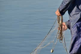 <p>Un pescador guarda las redes.</p>