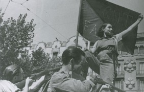 <p>Una miliciana del movimiento anarquista del CNT y la FAI despliega la bandera rojinegra en Barcelona (1936).</p>