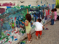 <p>Un grupo de niños pinta un mural.</p>
