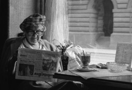 <p>Una señora mayor leyendo la prensa en un café de Praga.</p>