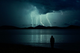<p>Una persona observa una tormenta lejana. </p>