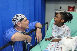 <p>Un médico atiende a una paciente en edad pediátrica. </p>