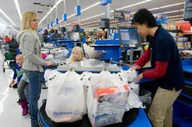 <p>Una cajera se afana por colocar en bolsas la compra de una mujer en un supermercado en EE.UU. </p>