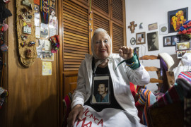 <p>Nora Cortiñas posa, durante la entrevista, con la foto de su hijo desaparecido y dos pañuelos característicos de la lucha feminista. / <strong>E. M.</strong></p>