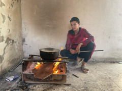 <p>Un joven desplazado prepara la comida para su familia en la escuela de Gaza en la que se refugian. / <strong>M.M. </strong></p>