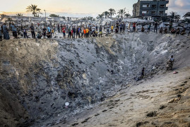 <p>Refugiados palestinos contemplan los daños causados tras el ataque aéreo israelí en Al-Mawasi. / <strong>Abed Rahim Khatib / Flash90</strong></p>