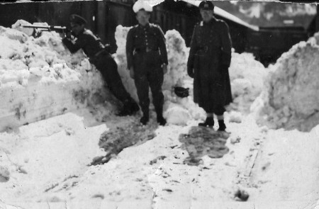 El guardia civil Antonio Benedé apuntando con el fusil junto a dos soldados alemanes en la estación de Canfranc en 1943.
