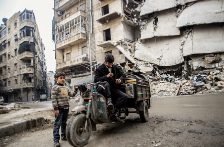 Un padre y un hijo recogen cosas de un edificio abandonado en el centro de Alepo. Miembros de Al-Qaeda se esconden en el área de Bustan al-Qaser donde se enfrentan al ejercito de al-Asad.