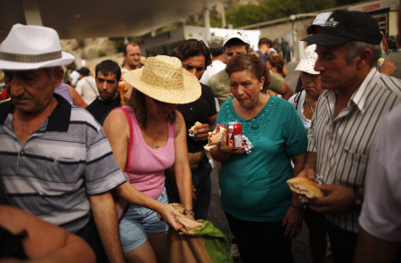 Agricultores temporeros y militantes del Sindicato Andaluz de Trabajadores (SAT) descansan para comer, durante la marcha organizada por el alcalde de Marinaleda en protesta por las reformas del Gobierno, en agosto de 2012.