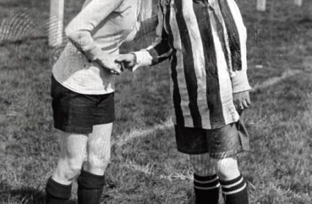 La capitana del Dick, Kerrs Ladies besa a la capitana del equipo  contrincante antes de un partido en Preston, Inglaterra en 1920. Cuando se quitaban el sombrerito, las obreras de la munición eran torreones formidables y ágiles.   