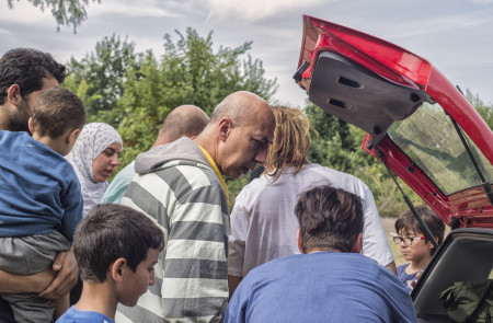 <p>Mahmoud Saad reparte comida entre refugiados sirios en la carretera que une Horgos (Serbia) con el paso fronterizo a Hungría.</p>