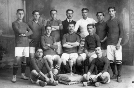 <p>El equipo España F.C de la temporada 1912/13 posando con la Copa de Campeones de Catalunya. De  izq. a dcha y de arriba a abajo: Reguera, Bau, Olivé, Vernet, Baró, Mariné, Duval, Graells, Passani, Miguel y Ramírez.</p>