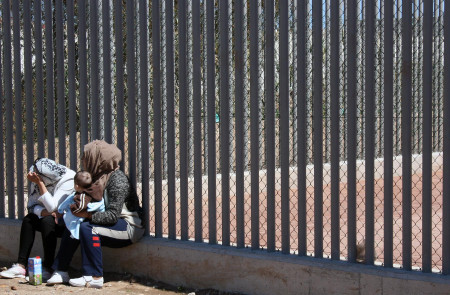 <p>Dos mujeres en la valla exterior del CETI de Melilla.</p>