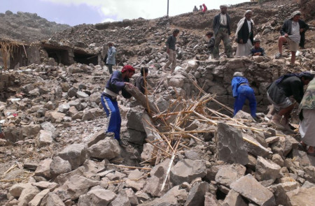 <p>Un grupo de hombres recorren los escombros de sus viviendas tras un bombardeo en Hajar Aukaish (Yemen) en abril del 2015.</p>