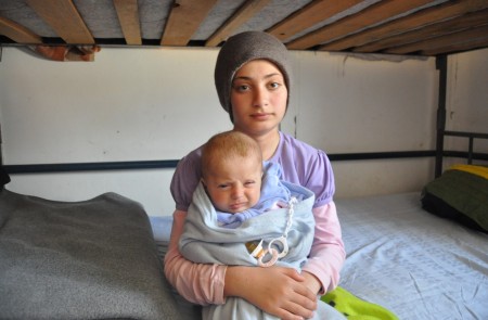 <p>La pequeña Abir, de 12 años, sostiene en brazos a su hermano de cuatro meses en el centro de refugiados de Krnjaca, en los suburbios de Belgrado. </p>
