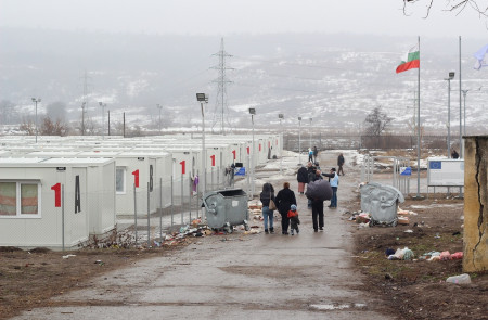 <p>Varias familias caminan entre los módulos prefabricados en los que viven los refugiados de origen sirio en Harmanli.</p>