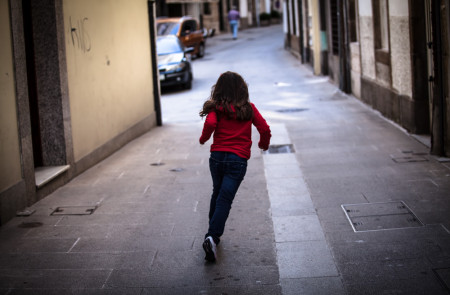 <p>Una niña corriendo por la calle.</p>