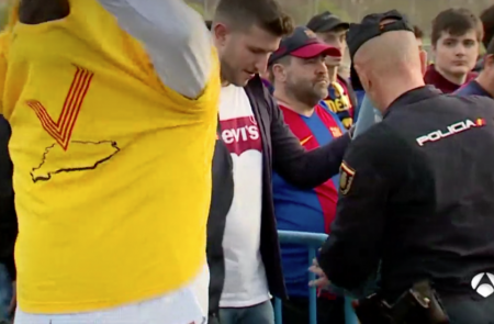<p>Un hombre se quita una camiseta de color amarillo durante un control policial en la final de la Copa del Rey. Madrid, 21 de abril de 2018</p>