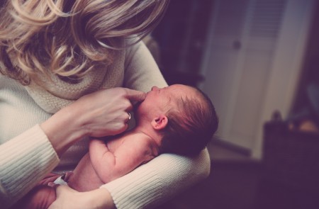 <p>Mujer con un bebé en brazos.</p>