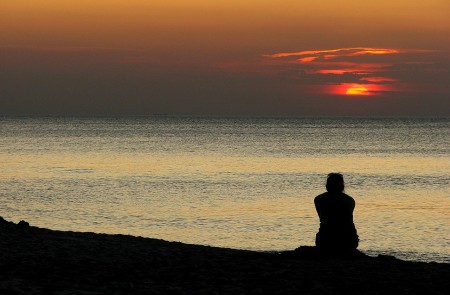 <p>Mujer en la playa durante la puesta de sol.</p>