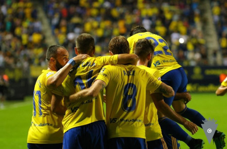 <p>Varios jugadores del Cádiz se abrazan en un partido contra la U.D. Las Palmas en 2019.</p>