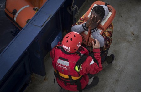 <p>Una mujer llega al barco de rescate después de ser recogida de una patera.</p>