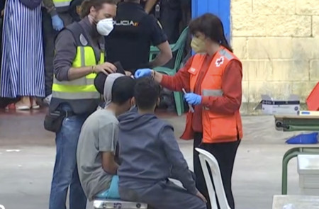 <p>Una voluntaria atiende a varios menores no acompañados a su llegada a Ceuta el pasado mes de mayo.</p>
