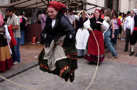 <p>Mujeres vestidas con el traje asturiano tradicional saltan a la comba. </p>