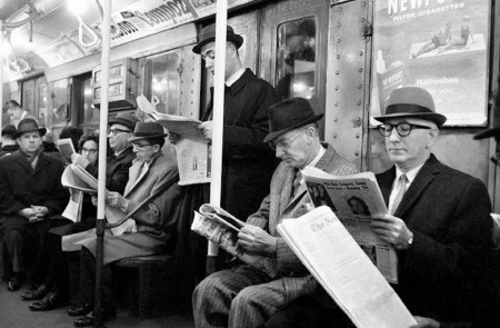 <p>Un grupo de personas lee el periódico durante el trayecto en metro. </p>