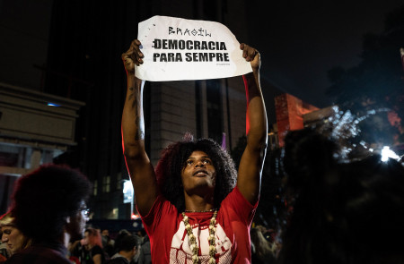 <p>Un manifestante en São Paulo porta una pancarta en repulsa al ataque violento al corazón de la democracia brasileña del 8 de enero. </p>