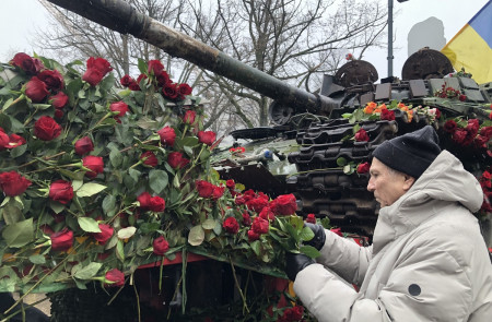 <p>Un manifestante por la paz coloca claveles rojos en los restos de un tanque ruso colocado frente a la embajada de dicho país.</p>