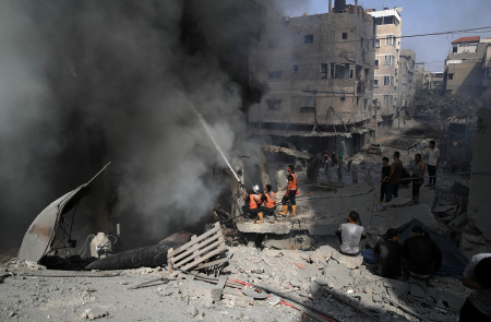 <p>Los bomberos se afanan por extinguir el fuego tras un bombardeo en Gaza. /<strong> Mohammed Zannoun</strong></p>